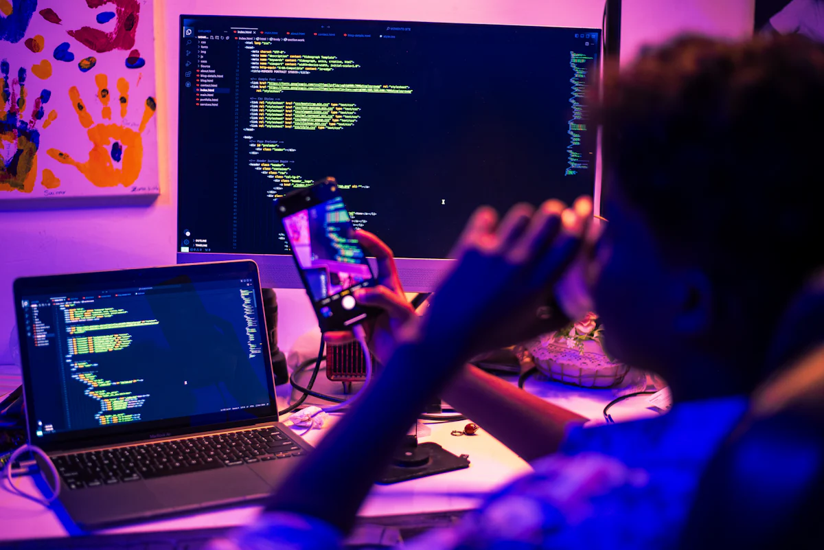 Developer coding on several screens at night